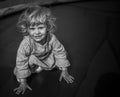 Adorable blonde toddler girl sitting on a trampoline