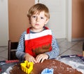 Adorable boy baking ginger bread cookies for Christmas Royalty Free Stock Photo