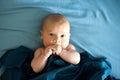 Adorable boy in the bedroom. A newborn baby is resting in a blue-colored bed.