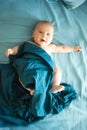Adorable boy in the bedroom. A newborn baby is resting in a blue-colored bed.
