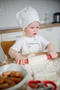 Adorable boy in chef hat and apron rolling out pastry dough Royalty Free Stock Photo