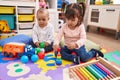 Adorable boy and girl playing with balls and hoops game at kindergarten Royalty Free Stock Photo