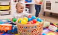 Adorable boy and girl playing with balls sitting on floor at kindergarten Royalty Free Stock Photo