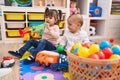 Adorable boy and girl playing trumpet holding balls at kindergarten Royalty Free Stock Photo