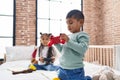 Adorable boy and girl playing video game sitting on bed at bedroom Royalty Free Stock Photo