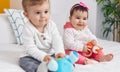 Adorable boy and girl sitting on bed playing with toys at bedroom Royalty Free Stock Photo