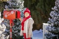 Adorable boy with glasses sending her letter to Santa, Christmas time Royalty Free Stock Photo