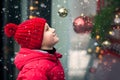 Adorable boy kid looking through the display window at Christmas decoration in the shop Royalty Free Stock Photo