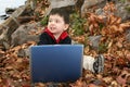 Adorable Boy In Leaves with Laptop Royalty Free Stock Photo