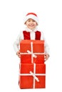 Adorable boy in santa clothes peeks out behind Christmas big gift boxs. Isolated white background. Royalty Free Stock Photo