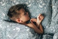 Adorable boy 6-7 years old sleeping in bed. Child having a good dreams