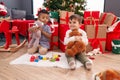 Adorable boys hugging teddy bear celebrating christmas at home