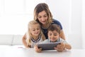 Adorable brother and sister young child using tablet with mother Royalty Free Stock Photo