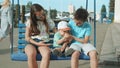 Adorable brothers and sister in amusement park. Cute siblings riding on swing Royalty Free Stock Photo