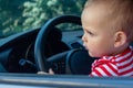 Boy sitting behind car wheel. Safety concept.