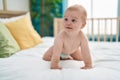 Adorable caucasian baby smiling confident crawling on bed at bedroom Royalty Free Stock Photo