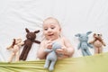 Adorable caucasian baby smiling confident lying on bed with dolls at bedroom Royalty Free Stock Photo