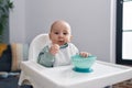 Adorable caucasian baby smiling confident sitting on highchair at home Royalty Free Stock Photo