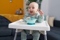 Adorable caucasian baby smiling confident sitting on highchair at home Royalty Free Stock Photo