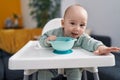 Adorable caucasian baby smiling confident sitting on highchair at home Royalty Free Stock Photo