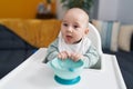 Adorable caucasian baby smiling confident sitting on highchair at home Royalty Free Stock Photo