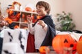 Adorable caucasian boy wearing vampire costume holding sweets at home Royalty Free Stock Photo