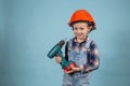 Adorable caucasian child in orange safety helmet,holdings crewdriver at hands. Royalty Free Stock Photo