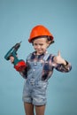 Adorable caucasian child in orange safety helmet,holdings crewdriver at hands. Royalty Free Stock Photo