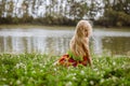 Sad girl sitting alone in the grass by the river Royalty Free Stock Photo