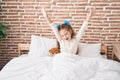 Adorable caucasian girl waking up stretching arms at bedroom Royalty Free Stock Photo