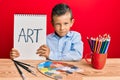 Adorable caucasian kid painter sitting at art studio holding art word skeptic and nervous, frowning upset because of problem Royalty Free Stock Photo