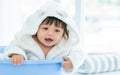 Adorable caucasian little baby daughter girl, wearing cute white bathrobe, taking bath in morning, sitting in baby bathtub, Royalty Free Stock Photo