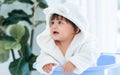 Adorable caucasian little baby daughter girl, wearing cute white bathrobe, taking bath in morning, sitting in baby bathtub, Royalty Free Stock Photo