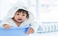 Adorable caucasian little baby daughter girl, wearing cute white bathrobe, taking bath in morning, sitting in baby bathtub, Royalty Free Stock Photo