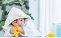 Adorable caucasian little baby daughter girl, wearing cute white bathrobe, taking bath in morning, sitting in baby bathtub, Royalty Free Stock Photo