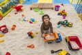 Adorable Caucasian little girl playing with the toys on the sand in the playground Royalty Free Stock Photo