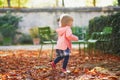 Adorable cheerful toddler girl running in Tuileries garden in Paris, France Royalty Free Stock Photo