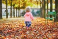 Adorable cheerful toddler girl running in Tuileries garden in Paris, France Royalty Free Stock Photo