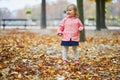 Adorable cheerful toddler girl running in Tuileries garden in Paris, France Royalty Free Stock Photo