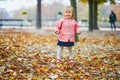 Adorable cheerful toddler girl running in Tuileries garden in Paris Royalty Free Stock Photo