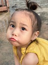 Adorable child Asian woman playing outdoor, happy cute little girl with funny face and looking to camera. Royalty Free Stock Photo