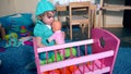 Adorable child dandle swing doll baby near toy crib bed