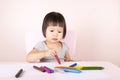 Adorable child drawing with colorful crayons.