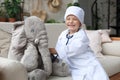 Adorable child dressed as doctor playing with toy elephant, checking its breath with stethoscope Royalty Free Stock Photo