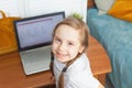 Adorable child girl learning at home. Little girl using laptop