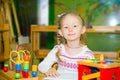 Adorable child girl playing with educational toys in nursery room. Kid in kindergarten in Montessori preschool class. Royalty Free Stock Photo