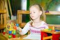 Adorable child girl playing with educational toys in nursery room. Kid in kindergarten in Montessori preschool class. Royalty Free Stock Photo