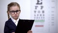 Adorable child girl pretending to be eye doctor, future profession optometrist Royalty Free Stock Photo