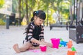 Adorable child girl with sand toys in sandbox. Outdoor creative activities for kids