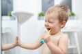 Adorable child learing how to brush his teeth